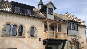 A historic building with a balcony, arched windows, and a tower.