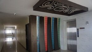 Un pasillo con un ascensor moderno y una cámara de seguridad.