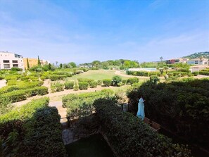 A landscaped garden with pathways, a statue, and a pool.