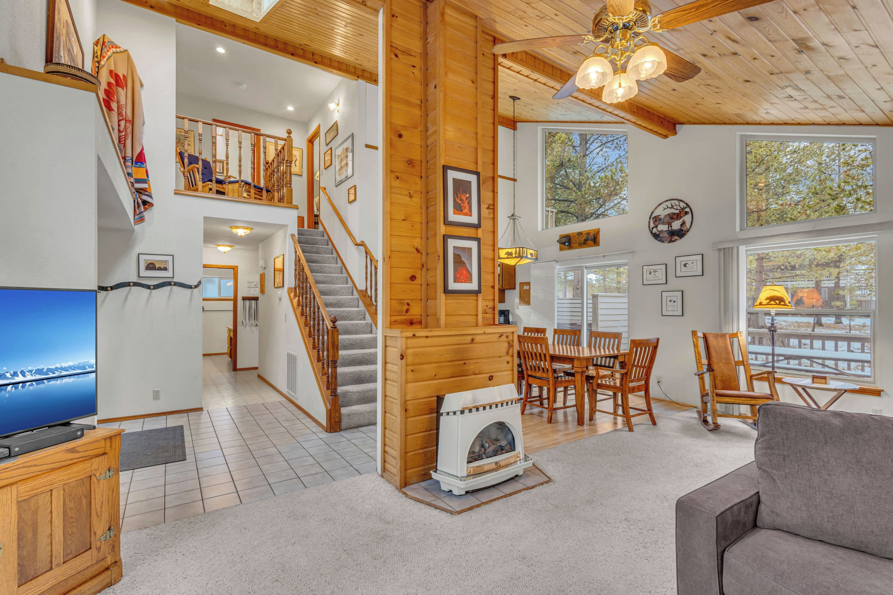 A spacious living area with a fireplace, wooden furniture, and a television.