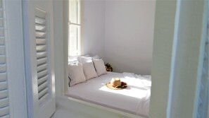 A small, white, single-bed room with a window and a door. - 30villa Rd in Rhodes (Rodos)
