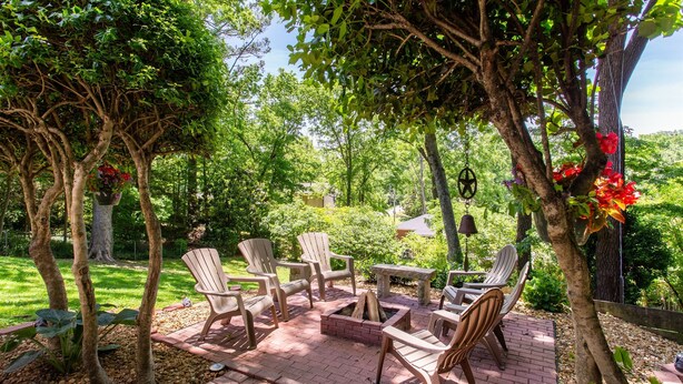 Un patio con sillas Adirondack, un brasero y una mesa.