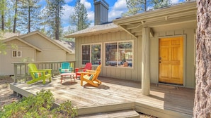 A wooden deck with Adirondack chairs and a wooden door. - AC, foosball, near play ground, hot tub (Sunriver)