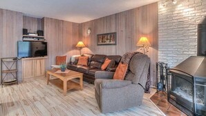 A cozy living room with a sofa, coffee table, and fireplace. - Inside Sunriver Village near local shops, eateries (Sunriver)
