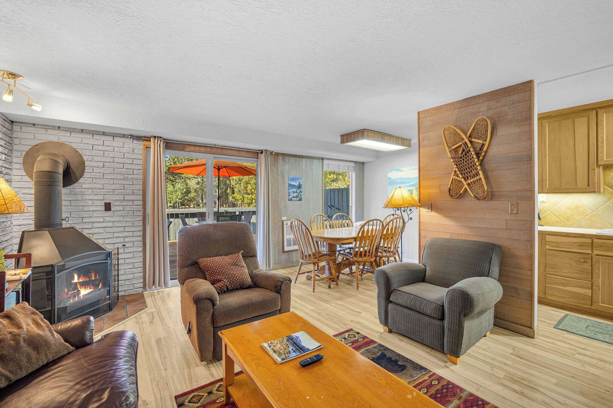 A cozy living room with a fireplace, comfortable seating, and a dining area.