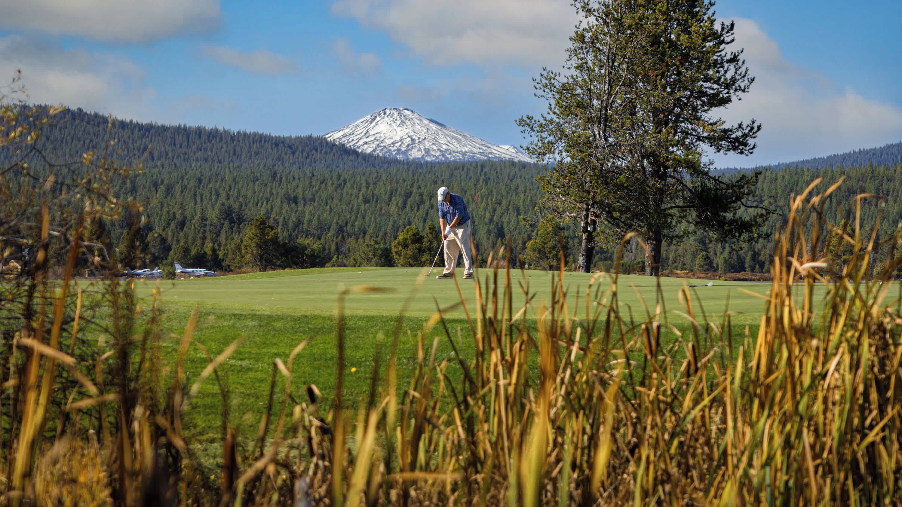 Un campo de golf con una montaña al fondo.