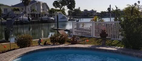 A swimming pool with a clear view of a marina and houses in the background.
