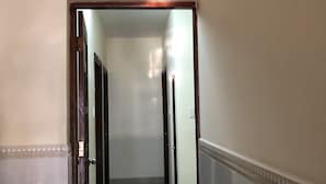 A hallway with a tiled floor, a red mat at the end, and a door on the left. - Hong Ngoc Hotel (Ho Chi Minh City)