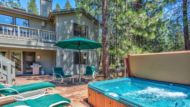 Une terrasse en bois avec des sièges d’extérieur, un jacuzzi et un patio couvert.