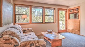 A cozy living room with a sectional sofa, a wooden coffee table, and a bookshelf. - Panoramic mountain views hot tub, air conditioning (Sunriver)