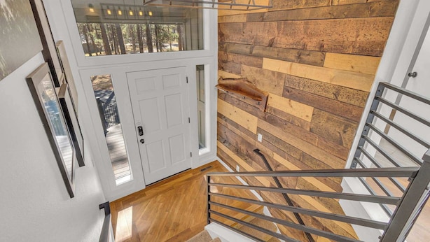 Un interior moderno con una pared de madera, una puerta blanca y una escalera de metal.