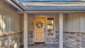 A house with a stone exterior, a wooden front door, and a wreath on the door. - Hot Tub, AC, Ping Pong, Foosball, 4bdrm, Family (Bend)
