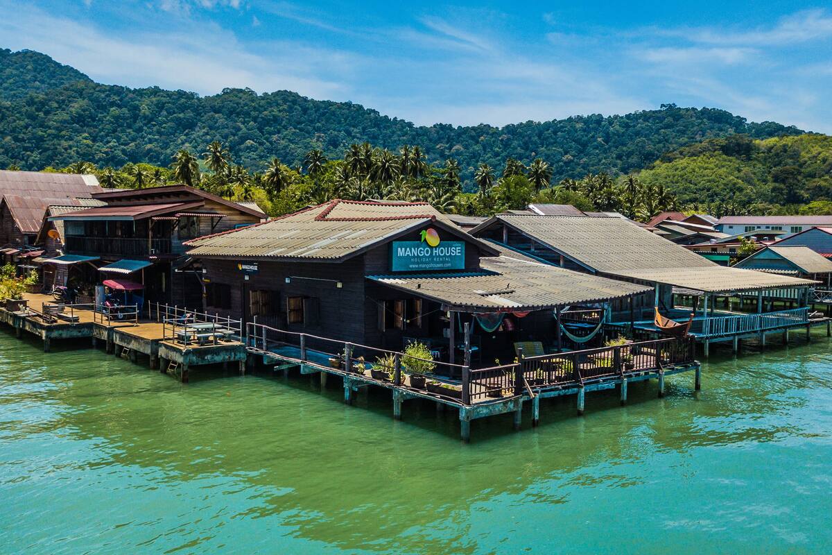 Una casa flotante con un letrero que dice "Mango House Holiday Rental".