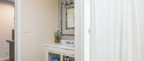 A bathroom with a white sink, mirror, and storage baskets.