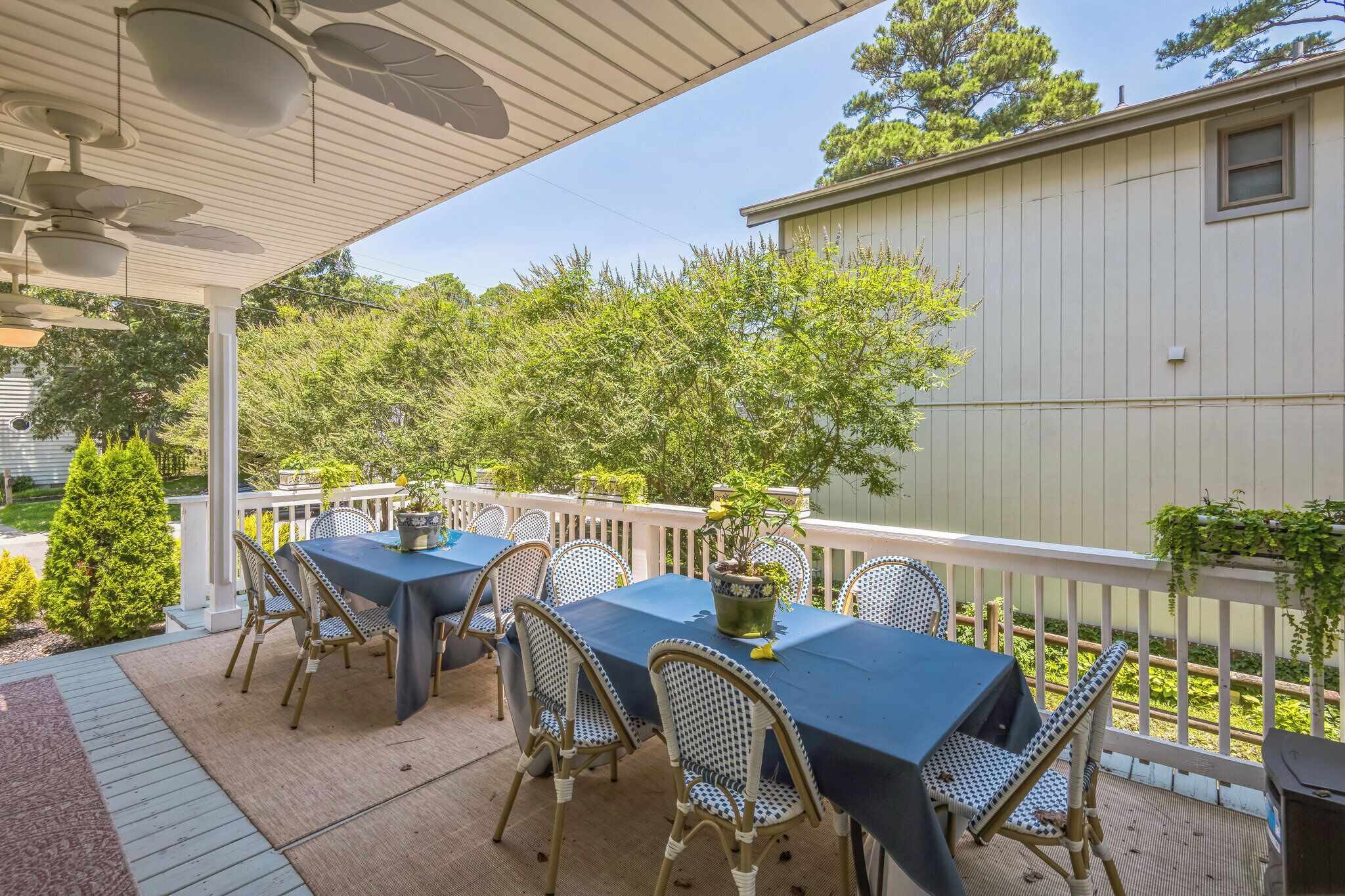 An outdoor patio with a covered seating area, tables, and chairs.