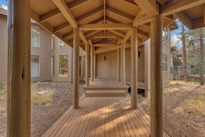 A covered outdoor area with wooden beams and a wooden deck. - Unique, spacious, private deck, HT, great room (Sunriver)