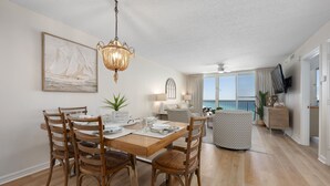 Un comedor con mesa de madera, sillas y una lámpara colgante.