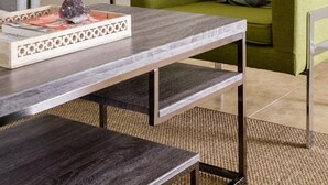 Un soggiorno moderno con una poltrona verde, un tavolino in legno e un cuscino a motivi geometrici.