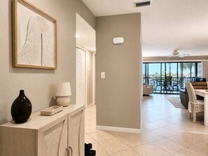 A modern interior with a kitchen area, dining space, and a view to the outside.