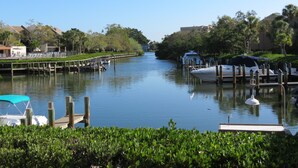 A marina with boats docked, a wooden walkway, and buildings in the background. - AJ's Bayside Treasure - Outstanding Waterfront Views & Private Beach Access! (Sarasota)