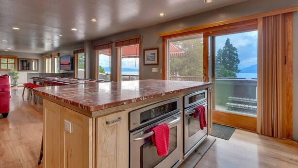 A spacious kitchen with a large island, built-in ovens, and a view of the outdoors.