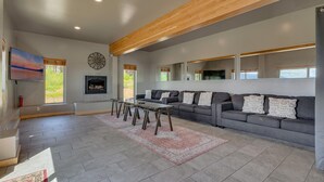 A spacious living room with a grey sofa, a coffee table, and a fireplace.
