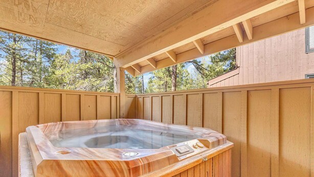 Ein Whirlpool auf einer Holzterrasse mit Blick auf Bäume.