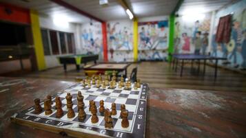A chessboard on a table in a room with colorful walls and a mural.