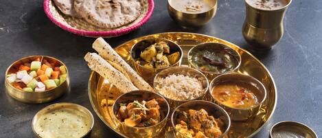 A traditional Indian meal with various dishes and utensils on a table.