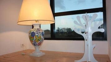 A table with a lamp and a white tree-shaped sculpture.