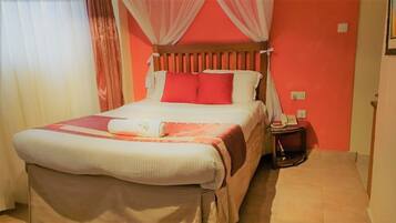 A hotel room with a bed, a bedside table, and a telephone.