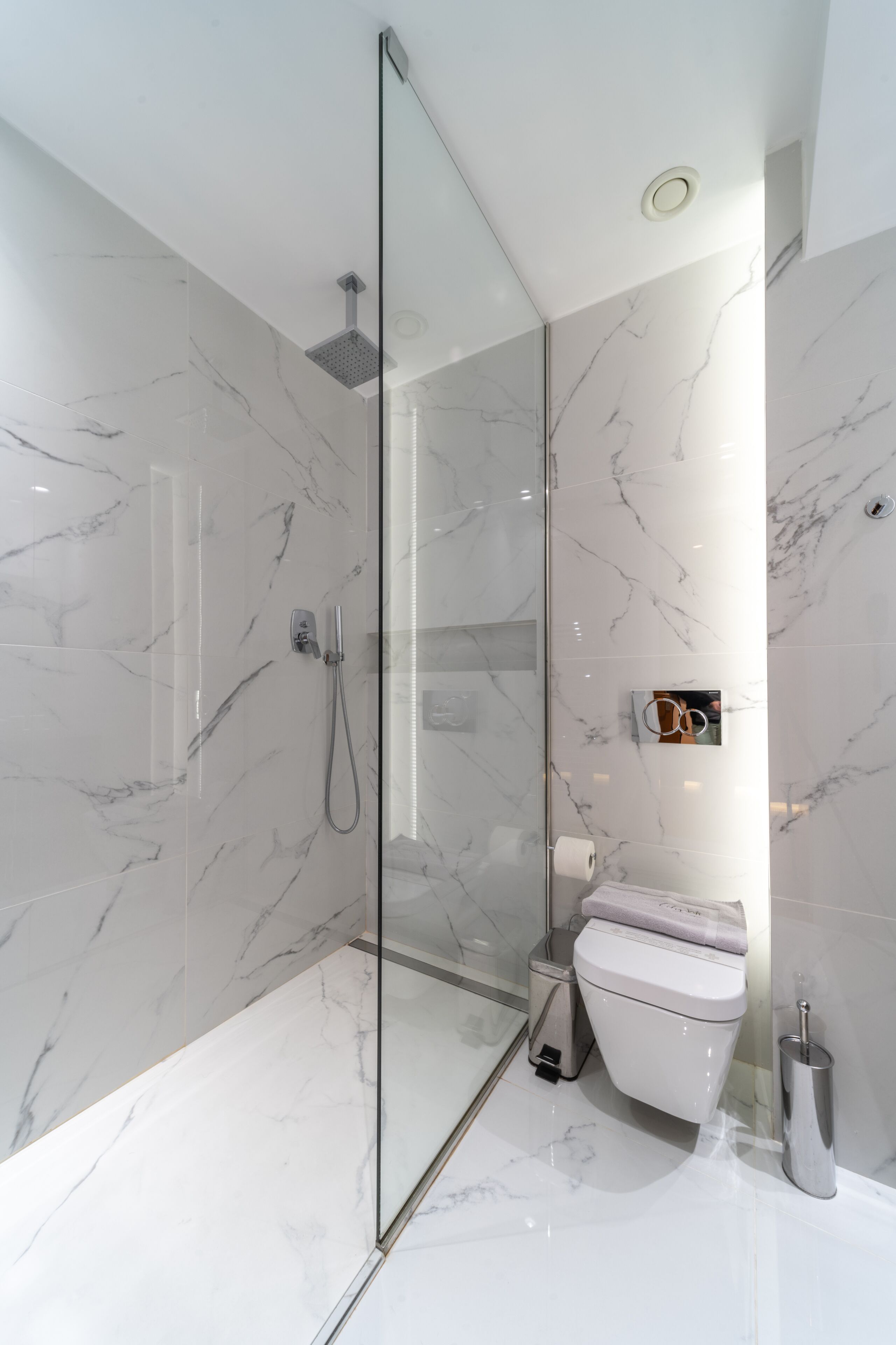 Un baño moderno con ducha de vidrio, inodoro y bidé.