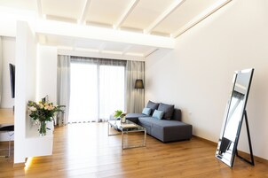 A modern living room with a sofa, coffee table, and a flat-screen TV.