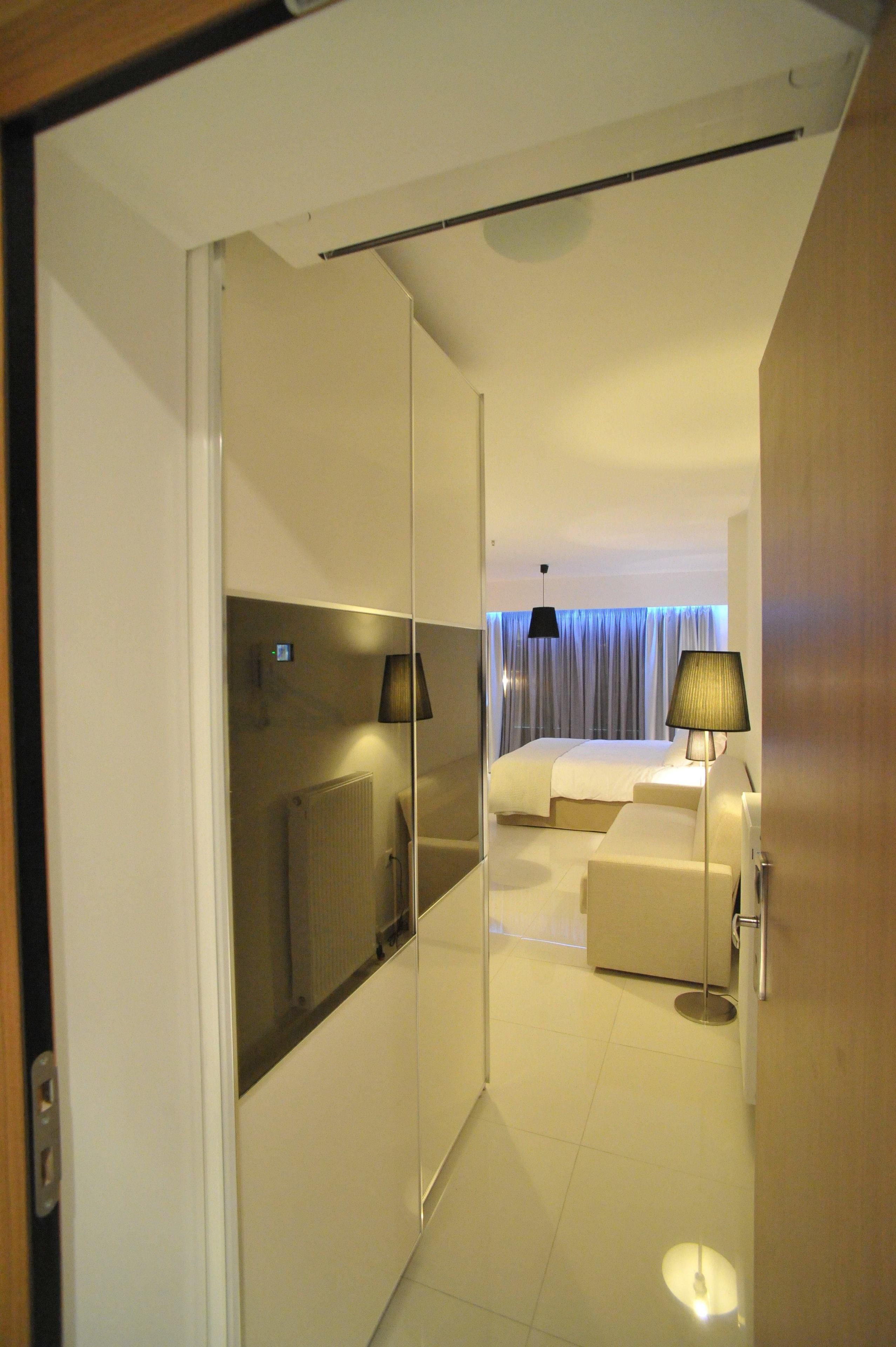 Une chambre d’hôtel avec un lit, une table de chevet, une lampe et un miroir.