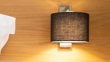 A wall-mounted light fixture with a cylindrical shade and a visible switch.