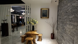 Un intérieur moderne avec une table à manger en bois, des bancs et une plante en pot.