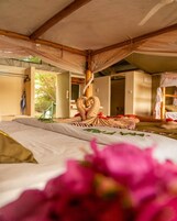 Una habitación con una cama, techo de madera y una ventana.