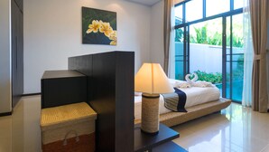 A modern hotel room with a bed, a lamp, a painting, and a view of greenery outside. - Onyx White Pearl Villa (Rawai)