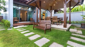 A modern outdoor patio with a wooden bench, chairs, and a table. - Onyx White Pearl Villa (Rawai)