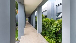 A covered corridor with columns and greenery on one side. - Onyx White Pearl Villa (Rawai)
