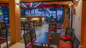 Un restaurant intérieur avec des meubles en bois, un coin bar et une vue sur l’extérieur.
