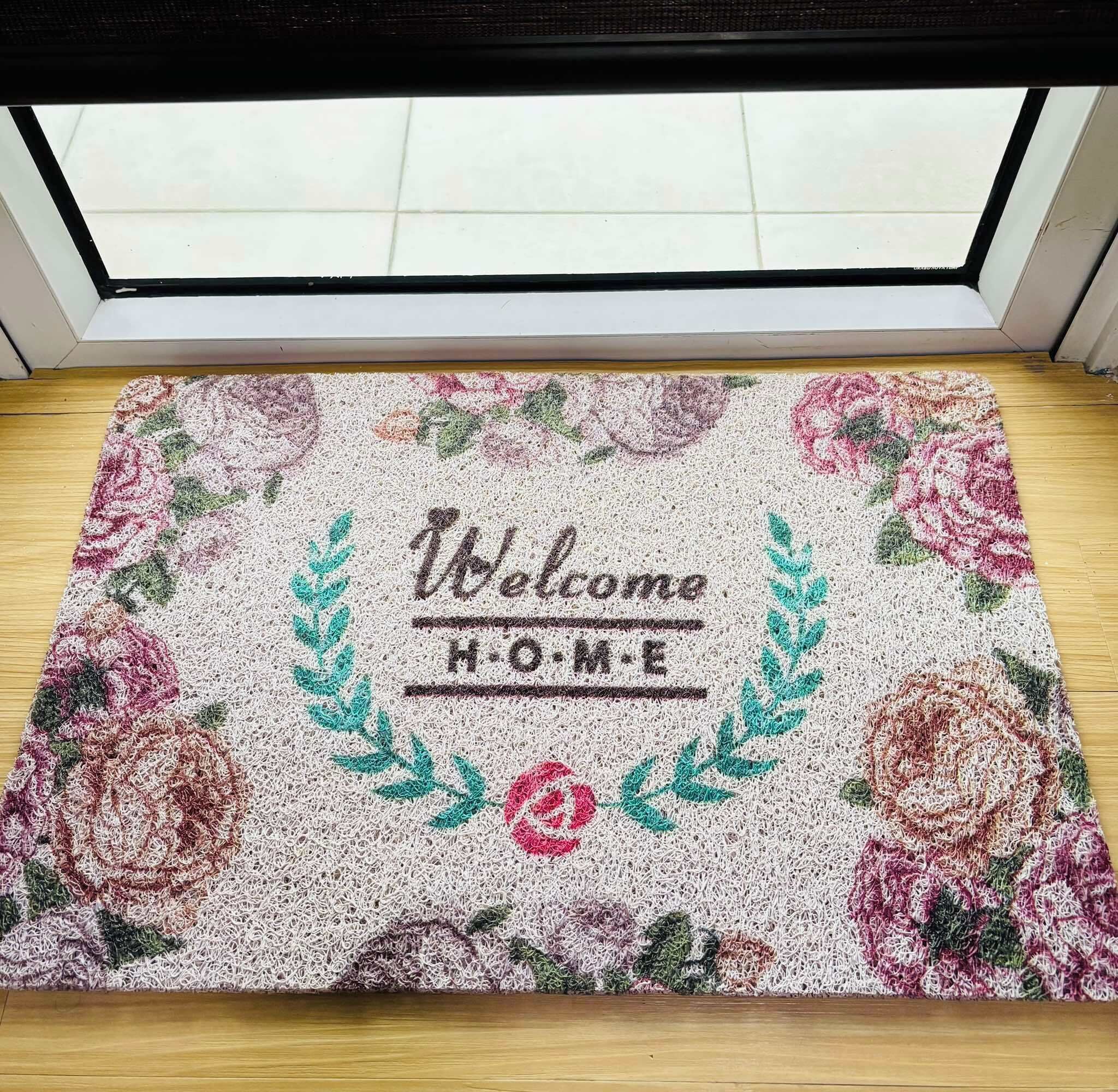 A welcome mat with floral patterns and the text "Welcome HOME" in the center.