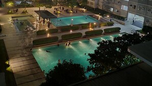 Un edificio residencial de varios pisos con zona de piscina.