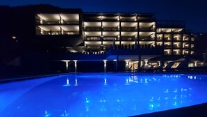 A modern building with multiple balconies and a swimming pool at night. - Molaris Lodge (Rio di Pusteria)