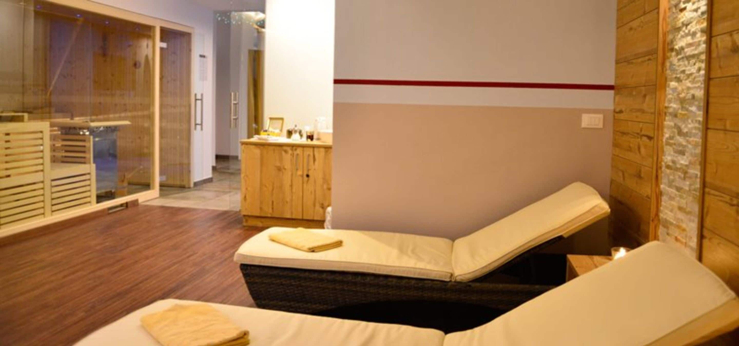 Une salle de spa équipée d’une table de massage, de meubles en bois et d’une paroi en verre.