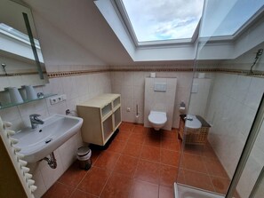 A compact bathroom with a skylight, a sink, a toilet, and a shower area. - Ferienwohnung Grünstein, 2 bis 4 Personen, 60 qm, 1 separates Schlafzimmer, Balkon (Schönau am Königssee)