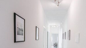 A hallway with white walls and a ceiling light fixture. - Casa Italia (Verona)