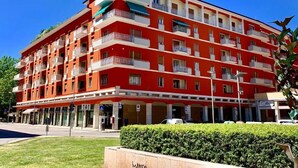 A multi-story hotel with balconies, a parking area, and a well-maintained lawn. - Casa Italia (Verona)
