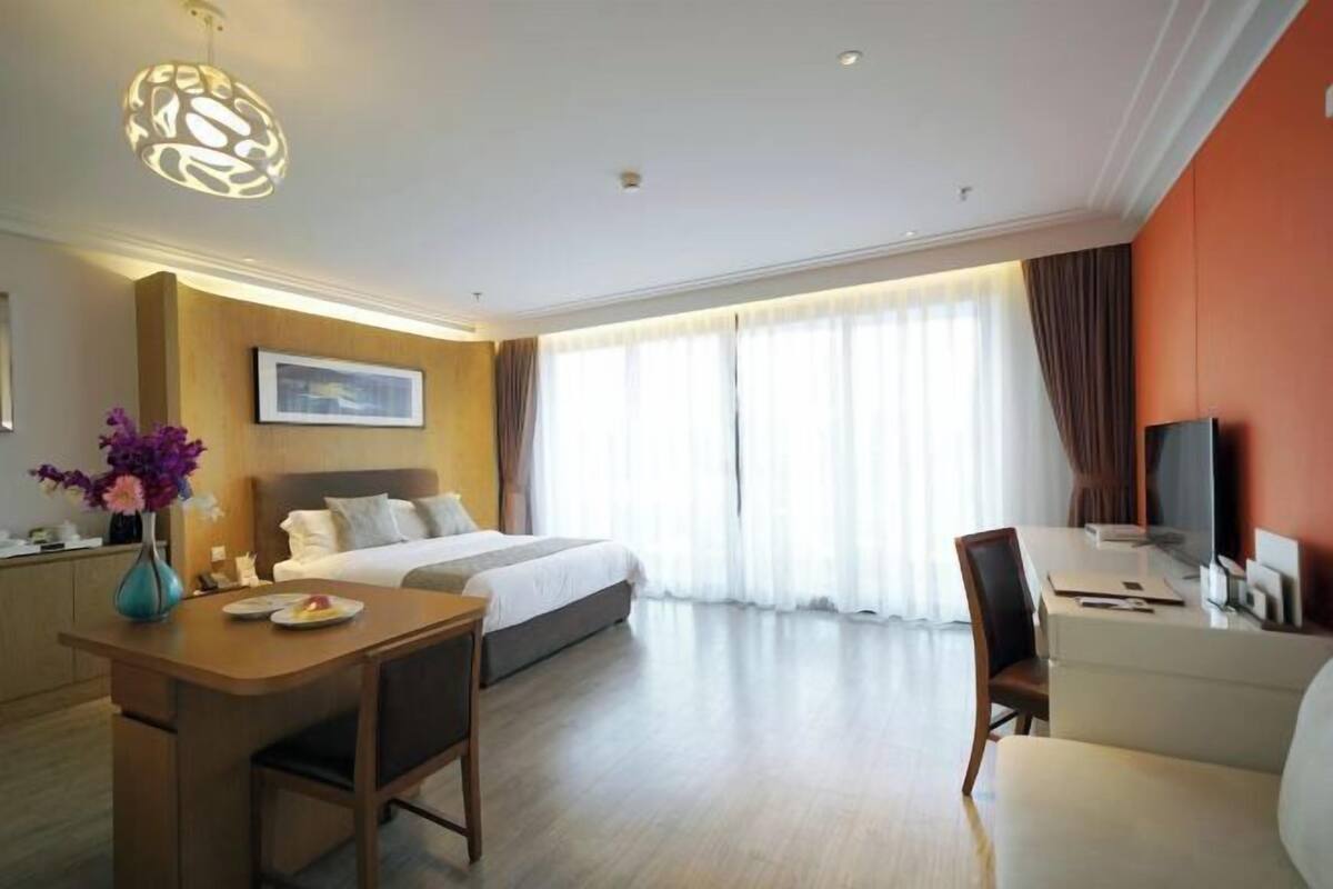 Ein Hotelzimmer mit Bett, Schreibtisch, Stuhl und Esstisch.