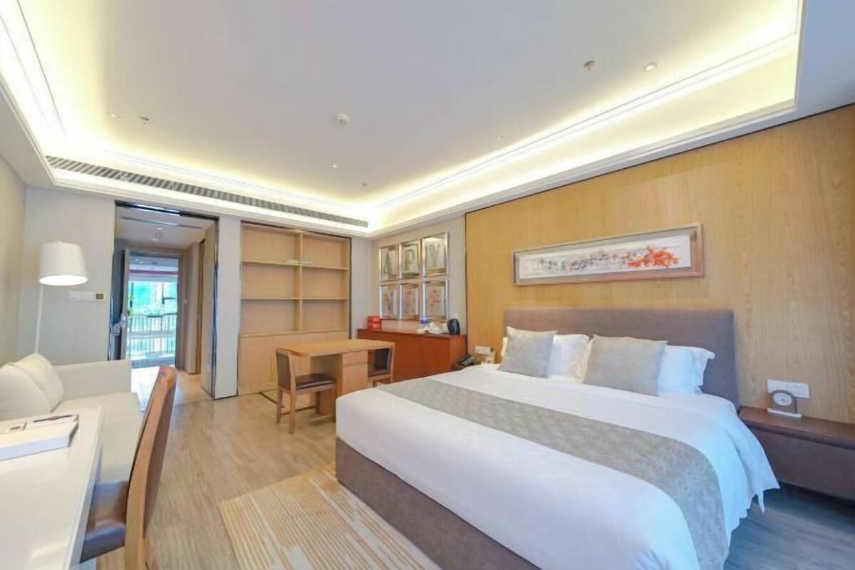 Ein Hotelzimmer mit Bett, Schreibtisch, Stuhl und Blick nach außen.